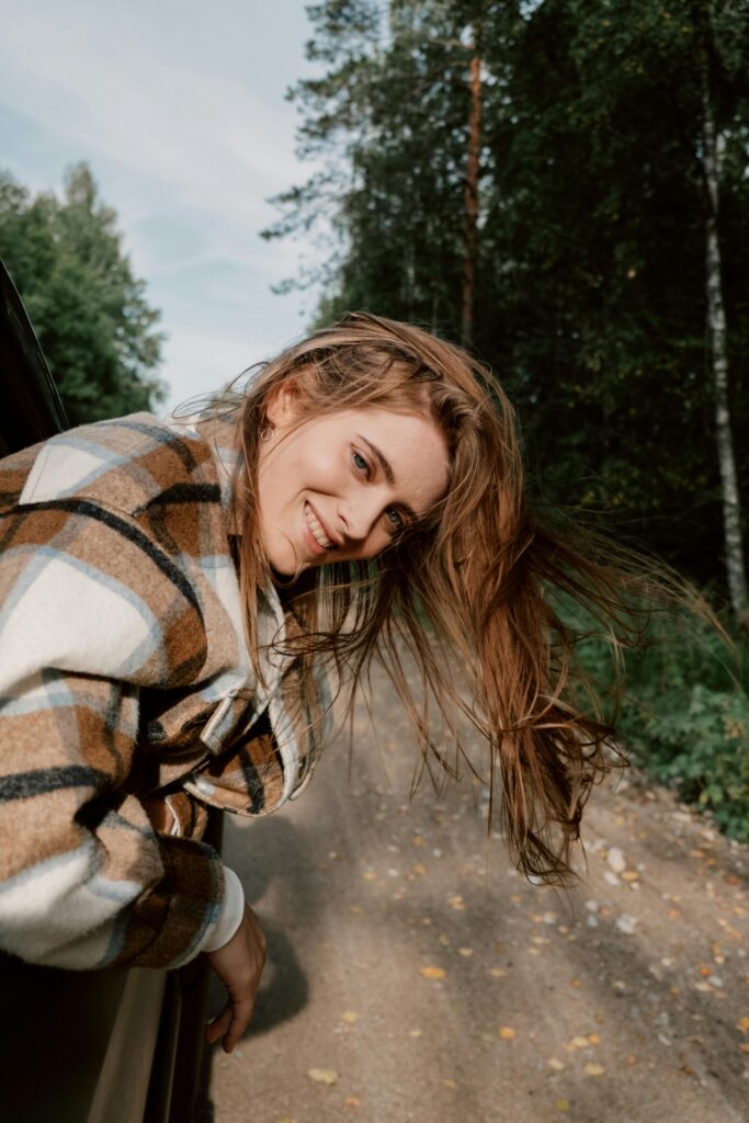 pexels-photo-5966345-5966345 Portrait of Smiling Woman on Dirt Road in Forest